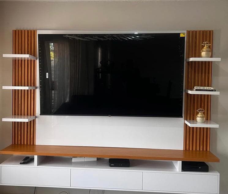 Media wall with timber slat panels, white floating shelves and a wood-topped console.