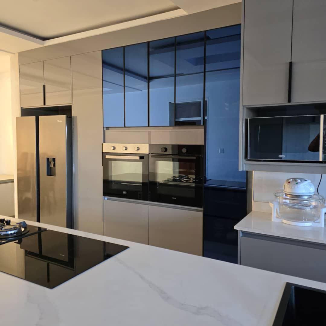 Taupe gloss kitchen with a built-in double oven column and marble-effect quartz tops.