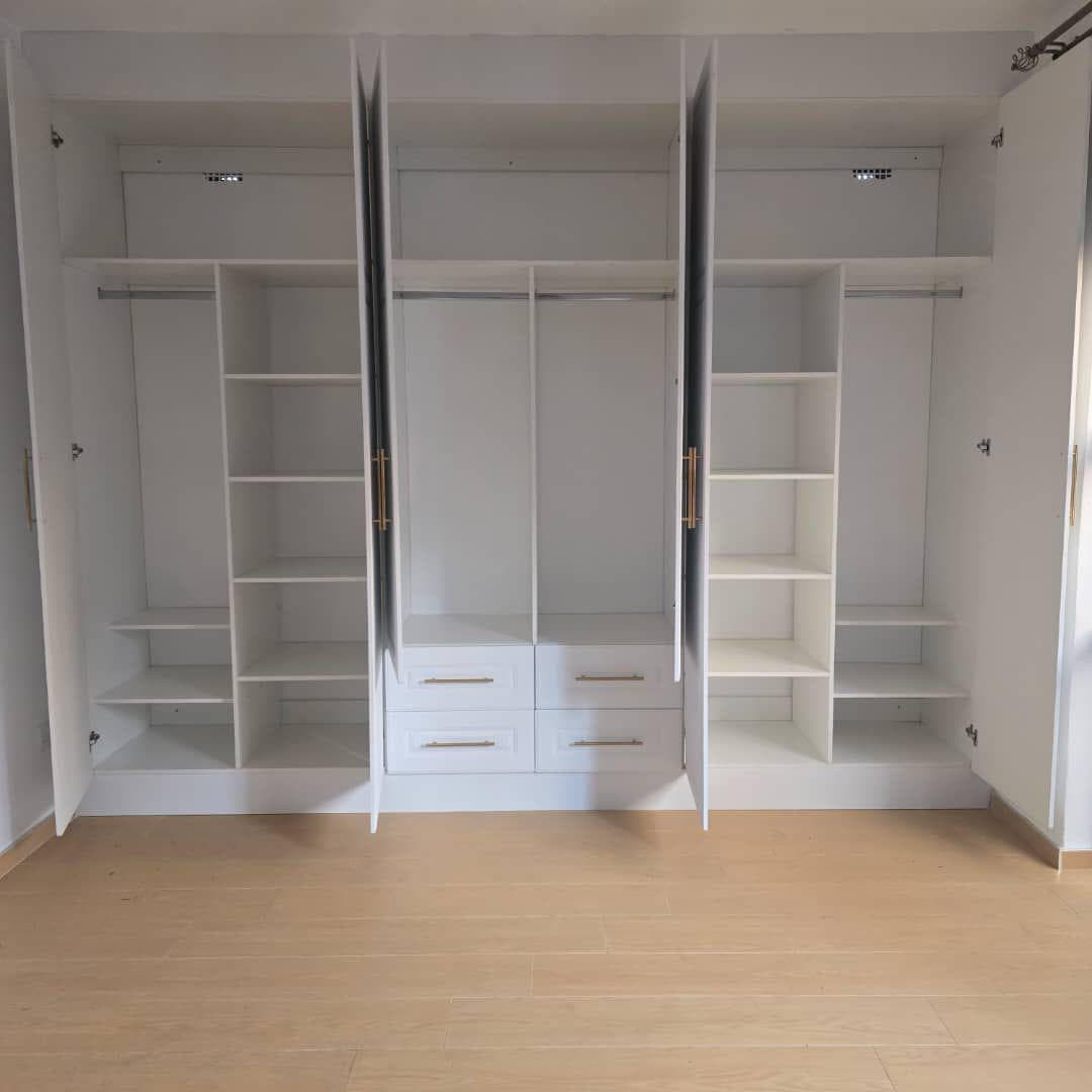 Fitted wardrobe opened to show adjustable shelving, hanging rails and drawer banks.