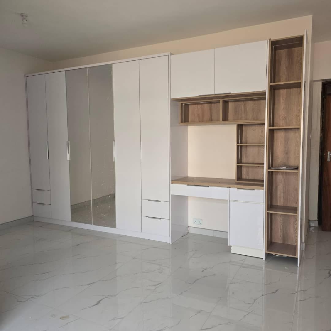 Fitted wardrobe combined with a built-in study desk, oak shelving and mirrored doors.